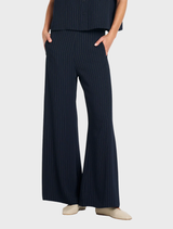 Navy and chalk striped suit pants with elasticated back waist and front welt pockets, designed for a modern minimalist look.