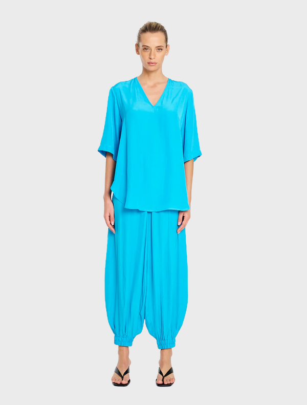 Swish Plaza Top in cerulean blue, featuring a modern design and lightweight fabric, perfect for casual or dressy occasions.