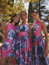 Elegant strapless maxi gown featuring a blue floral print on pink, with ruffles and detachable straps for versatile styling.