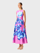 The Sybella Midi Dress showcases a pink and blue floral design, boat neckline, and gathered skirt, perfect for garden parties.