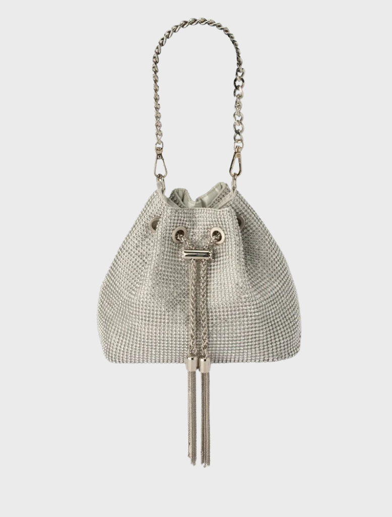 Small leather bucket bag in silver with a tassel on the handle, identified as the Sylvie Crystal Pouch.