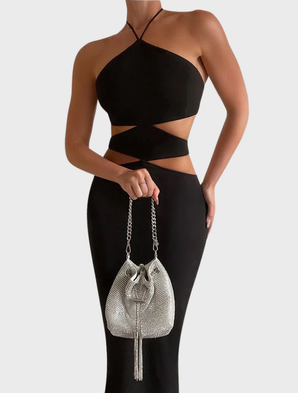 A woman in a black dress holding a silver Sylvie Crystal Pouch purse.
