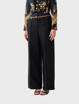 High-waisted silk-wool pant with waist button detail, blending timeless tailoring with inspiration from matador costumes.