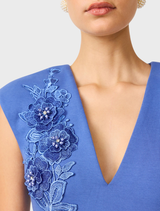 Talitha's cornflower blue dress, designed as a column style with a plunging neckline, exudes elegance and sophistication.