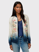 Teresa Reversible Bomber Jacket in ombre design, showcasing floral embroidery and blue ribbing, styled for versatile wear.