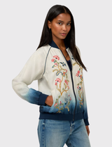 Reversible bomber jacket in ombre white to blue, featuring floral embroidery and contrasting blue ribbing at cuffs and waist.