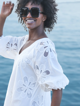 Stylish white Girl Boss Blazer draped over a chair, emphasizing its contemporary design and professional appeal.
