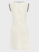 A white dress adorned with black polka dots, complemented by a sleek black trim around the edges.