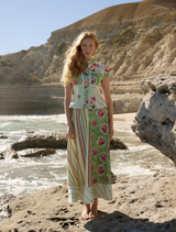A woman stands on a rock, wearing a Tillla Denim Maxi Skirt in a Meadow Multi pattern.
