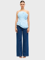 Baby blue Tremail top displayed on a hanger, featuring a simple design and lightweight fabric suitable for casual wear.