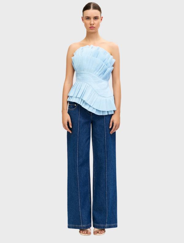 Baby blue Tremail top displayed on a hanger, featuring a simple design and lightweight fabric suitable for casual wear.