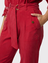 Fashionable dahlia red jogger pants constructed from silky cupro-viscose, featuring tapered cuffs and utility-style pocket accents.