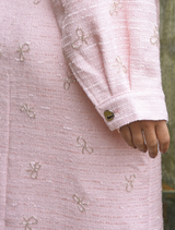 Feminine pink tweed skirt featuring a classic cut and rich texture, suitable for a variety of stylish outfits.