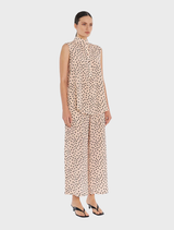 The model is dressed in a pink polka dot top and pants, highlighting the Tab Slide Tank style in Meringue/Black.