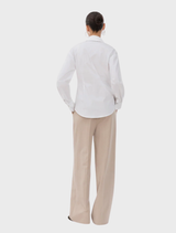 A white Ullismd shirt laid flat, showcasing its design and fabric texture.