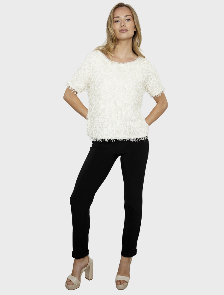 Vanilla knit top draped elegantly, emphasizing its lightweight texture and versatile style for various looks.