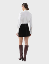 Elegant chocolate velvet mini skirt, highlighting a plush fabric and modern silhouette for versatile styling options.