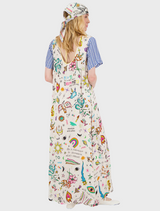 A woman models a dress adorned with bright, intricate patterns, highlighting her fashion sense and individuality.