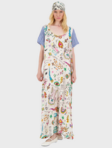 A woman in a vibrant, patterned dress stands confidently, showcasing colorful designs that reflect her unique style.