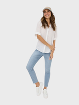 White Veri Linen Blouse, emphasizing its airy fabric and refined style, presented on a hanger.