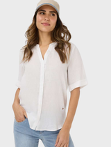 White Veri Linen Blouse displayed on a hanger, showcasing its lightweight fabric and elegant design.