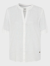 A white linen blouse by Veri, featuring a simple yet stylish design, hanging against a neutral background.