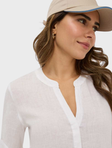 White Veri Linen Blouse displayed on a hanger, showcasing its lightweight fabric and elegant design.