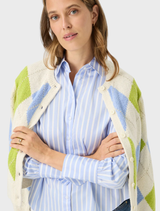 Vica's blue shirt with stripes, perfect for adding a touch of elegance to everyday outfits.