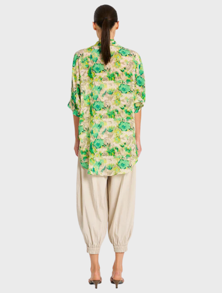  The model wears a vibrant green and yellow floral shirt, emphasizing a fresh and summery aesthetic.