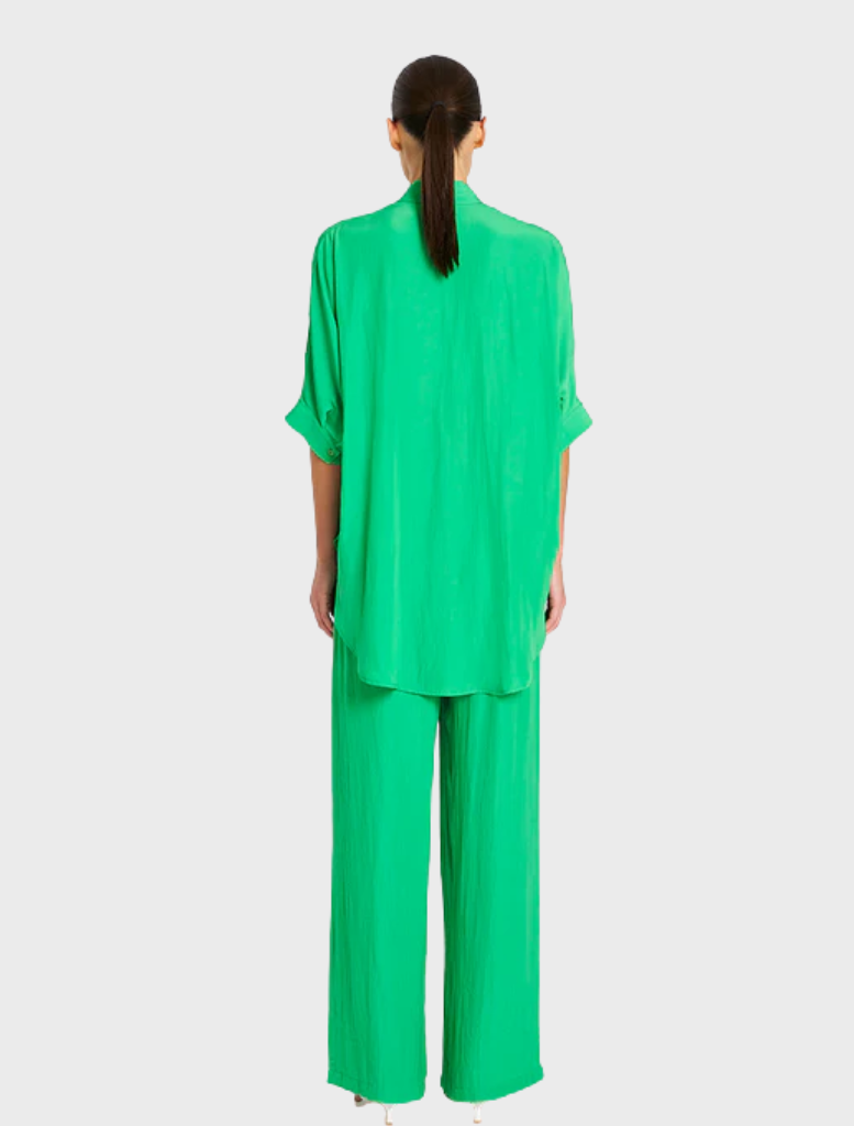 Green silk pajama set displayed on a neutral background, showcasing its smooth texture and elegant design.