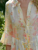 A woman in a vintage floral shirt and necklace, showcasing the Get Shirty Dress collection.