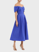 A blue dress adorned with a ruffled neckline, offering a playful and elegant touch to the outfit.