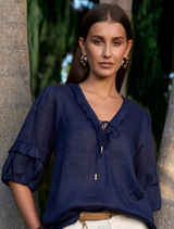 Indigo ramie blouse with deep V neckline, hook-and-eye closure, blouson sleeves, and side splits for added comfort.