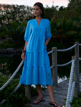 Ramie midi dress in bluebell with V-neck, gathered sleeves, tiered skirt, raw bias trim, and hidden side pockets for functionality.