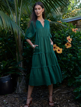 Tiered jungle green ramie midi dress featuring a V-neck, full sleeves with elastic cuffs, and hidden side seam pockets.