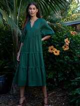 Jungle green ramie midi dress with V-neck, full sleeves, elastic cuffs, tiered skirt, and discreet side seam pockets.
