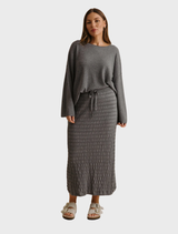 Elegant pleat skirt in ash, crafted from soft Merino cotton, ideal for versatile styling in various settings.