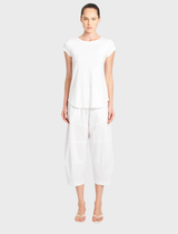 Interior of a white-themed café featuring comfortable seating, soft lighting, and a welcoming atmosphere for visitors.