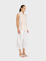 White cropped Tuscan pants draped elegantly, featuring a contemporary cut ideal for both casual and dressy occasions.