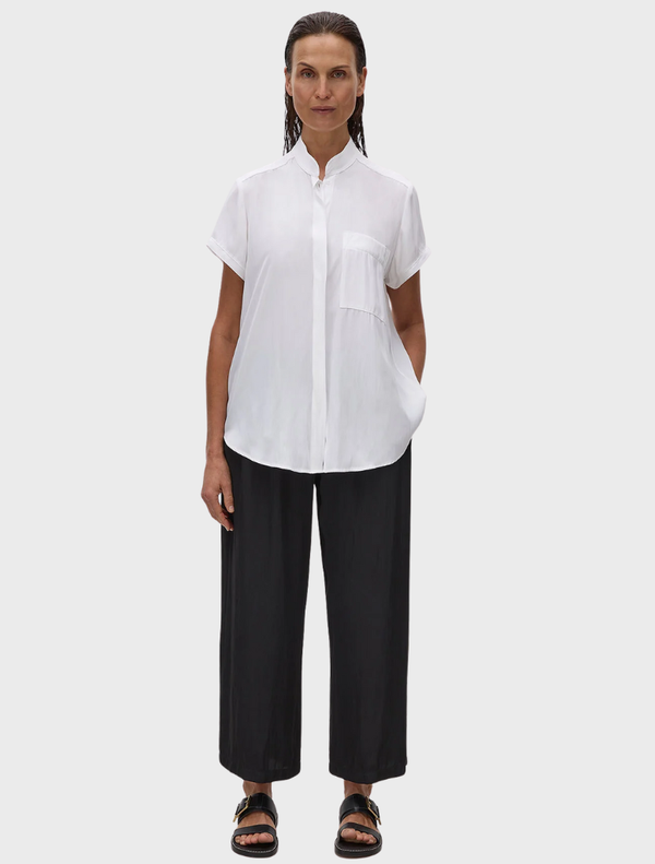 A white Mache Stand Shirt on a hanger, showcasing a sleek design with a stand collar and button closure.