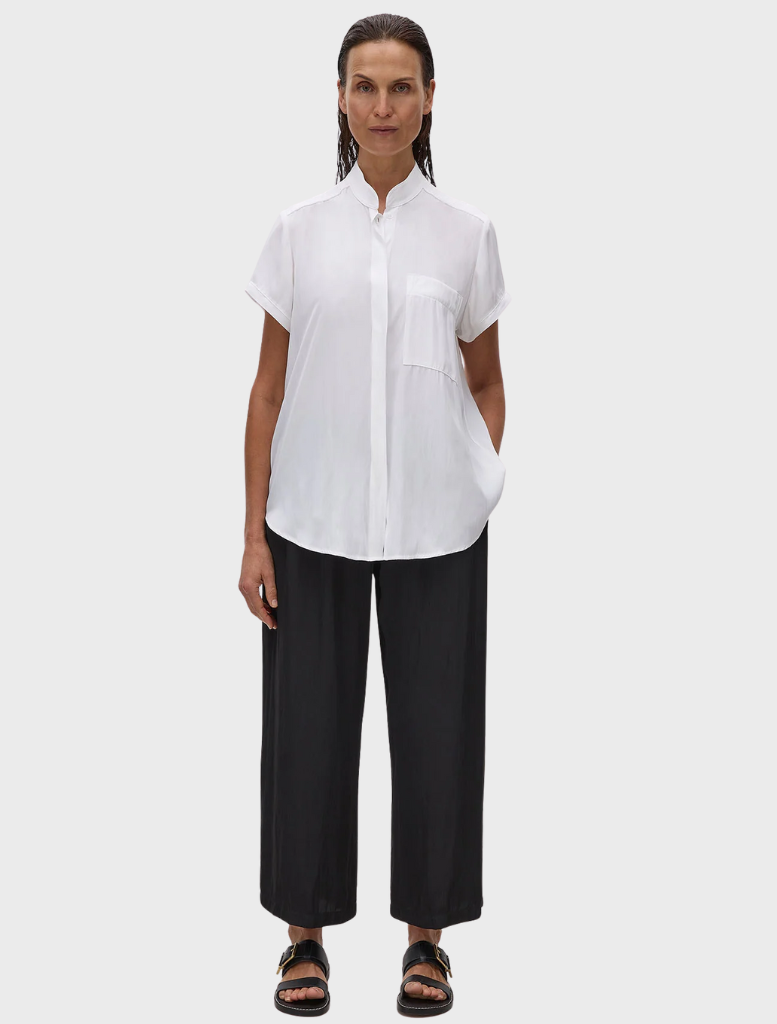 A white Mache Stand Shirt on a hanger, showcasing a sleek design with a stand collar and button closure.