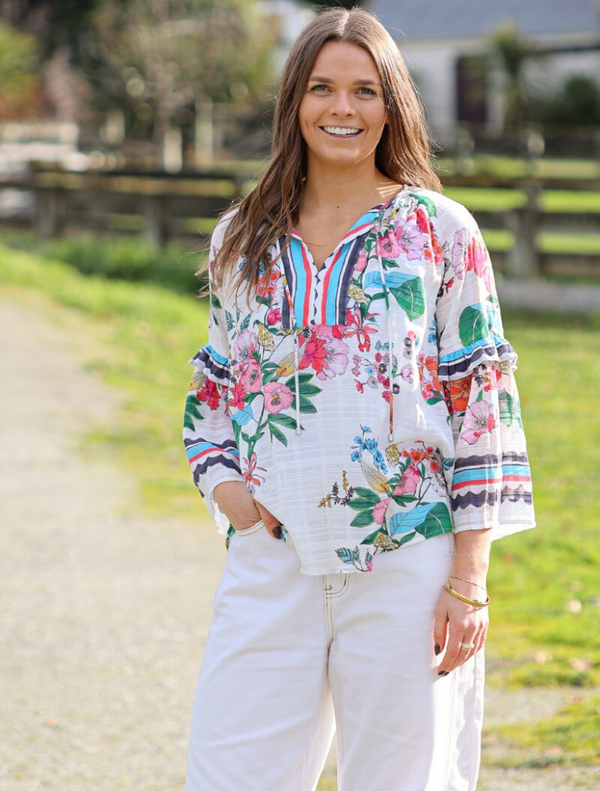 White floral dress with long sleeves and a ruffled skirt, identified as Pandora Blouse - White Multi.