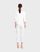 Close-up of a white relaxed boat neck top, emphasizing its smooth texture and laid-back aesthetic.