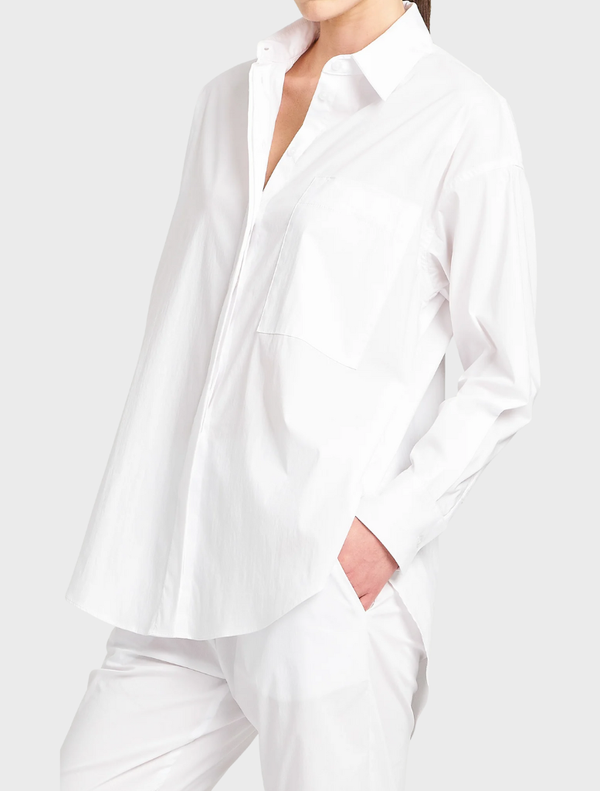 A white relaxed pocket shirt laid flat, showcasing its soft fabric and casual fit.