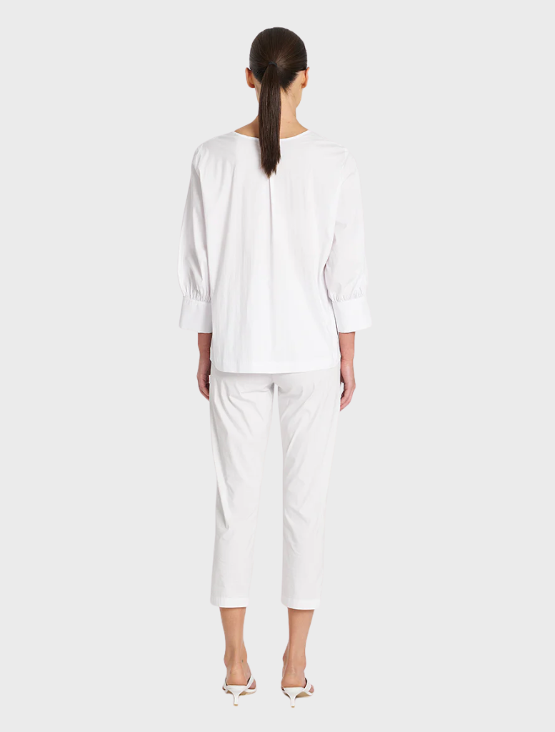 This white top, made of cotton, showcases puff sleeves for a fashionable and airy appearance.