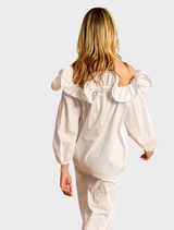 White Riva ruffled shirt laid flat, emphasizing its stylish ruffle details and clean lines.
