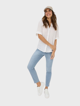 Elegant white linen blouse from Veri, highlighting its soft texture and classic silhouette on a hanger.
