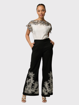 Breathable black wide-leg pant with embroidery on the front, elasticated back waistband, and functional hip pockets.
