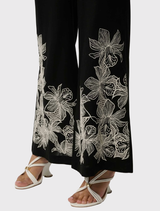 Sophisticated black wide-leg trousers in a linen-viscose blend, highlighting front embroidery and an elastic waistband for convenience.