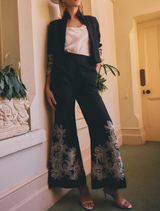 Black wide-leg pant made of linen-viscose blend, featuring embroidery on the front leg and an elasticated back waistband.